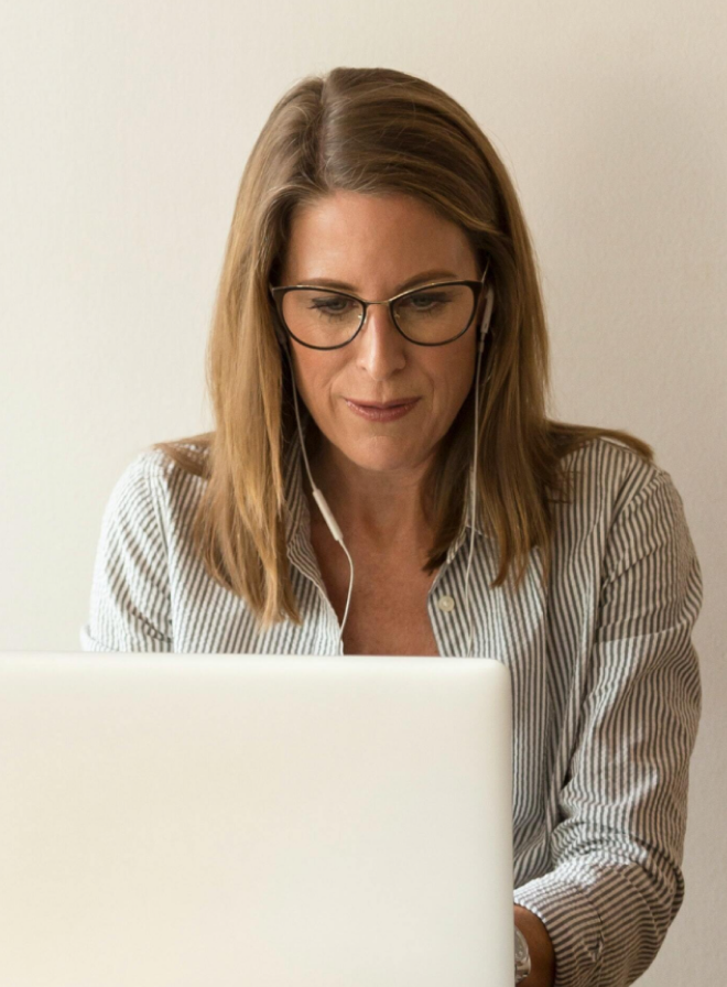 Una donna lavora al computer, seduta alla scrivania di un ufficio.